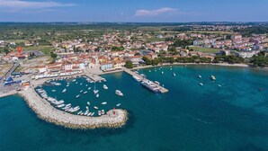 An aerial view of a coastal town with a marina, buildings, and a prominent church. - Nice apartment in Fazana with WiFi (Fazana)