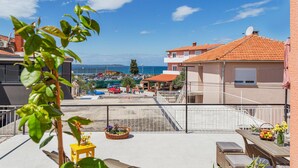 A rooftop terrace with a view of the sea, a parking area, and a building with a tiled roof. - Nice apartment in Fazana with WiFi (Fazana)
