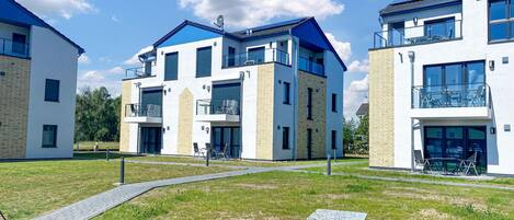 Een modern appartementencomplex met meerdere units, elk voorzien van balkons en grote ramen.