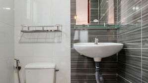 A bathroom with a toilet, a sink, and a mirror.
