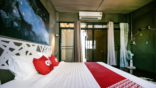 Habitación de hotel con una cama grande, un mural temático de galaxia y un diseño moderno.