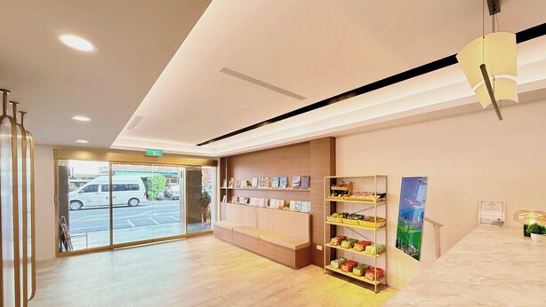 A hotel lobby with a reception desk, a seating area, and a display of snacks. - Cloud Haku Cozy Inn (Taitung)