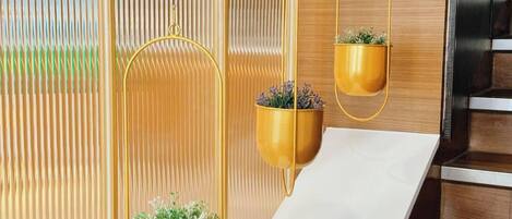 A staircase with a modern design, featuring a wooden finish and a white wall with vertical lines.