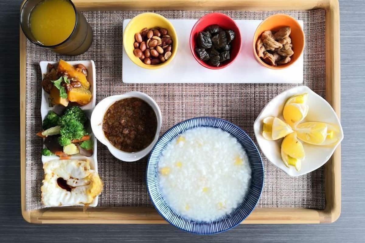 Una bandeja con diferentes platos, como arroz, verduras y frutas.