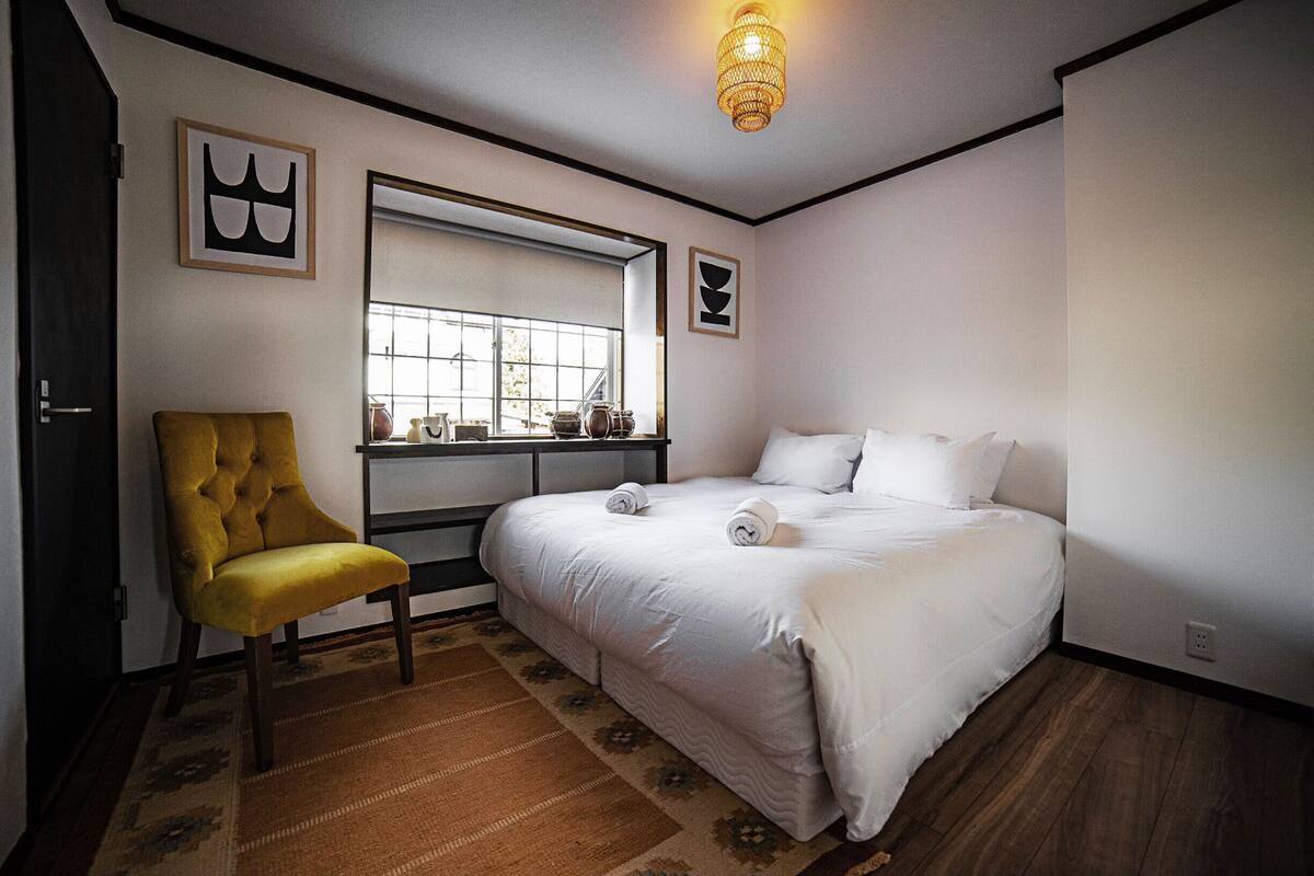 Une chambre Ă coucher avec un lit, une fenĂȘtre, une chaise et un tapis.