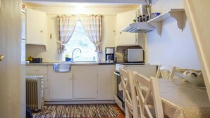 A compact kitchen with a window, a coffee maker, a toaster, and a radiator. - 2 bedroom stunning home in Flekkefjord (Flekkefjord)