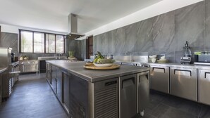 Uma cozinha moderna com eletrodomésticos de aço inoxidável, uma ilha central e uma bancada de mármore.