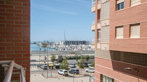 Een uitzicht op een jachthaven met boten, een parkeerplaats en een gebouw met een bakstenen gevel.