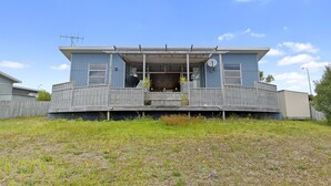 A two-story house with a balcony, a satellite dish, and a small front porch.