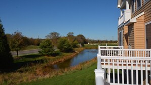 A residential building with a white balcony, a river, and a road in the background. - Spacious Townhouse Amenity Rich Rehoboth Beach (Rehoboth Beach)