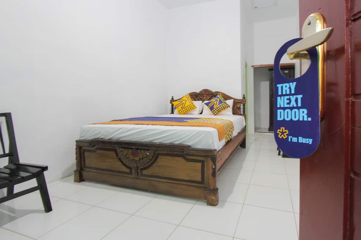 A bedroom with a wooden bed, a chair, and a door with a sign.
