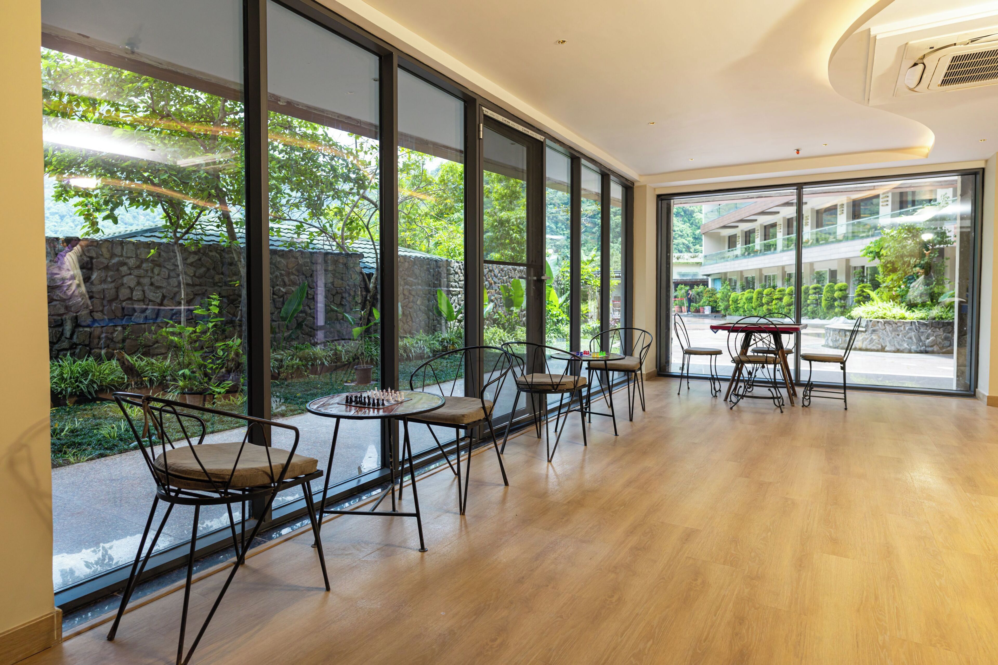 Une pièce spacieuse avec de grandes fenêtres, un plancher en bois et un mobilier moderne.