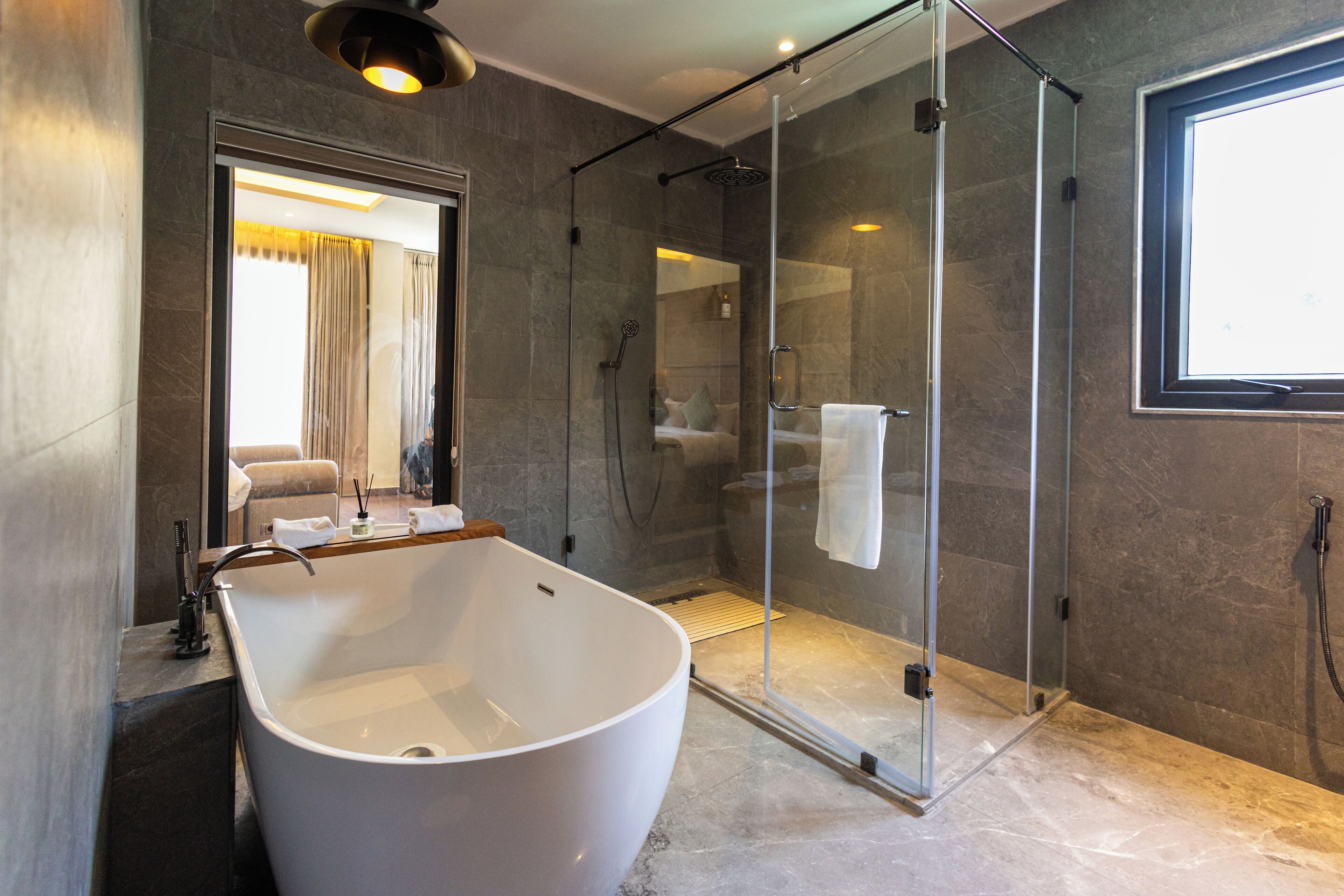 A modern bathroom with a freestanding bathtub, a glass-enclosed shower, and a large mirror.