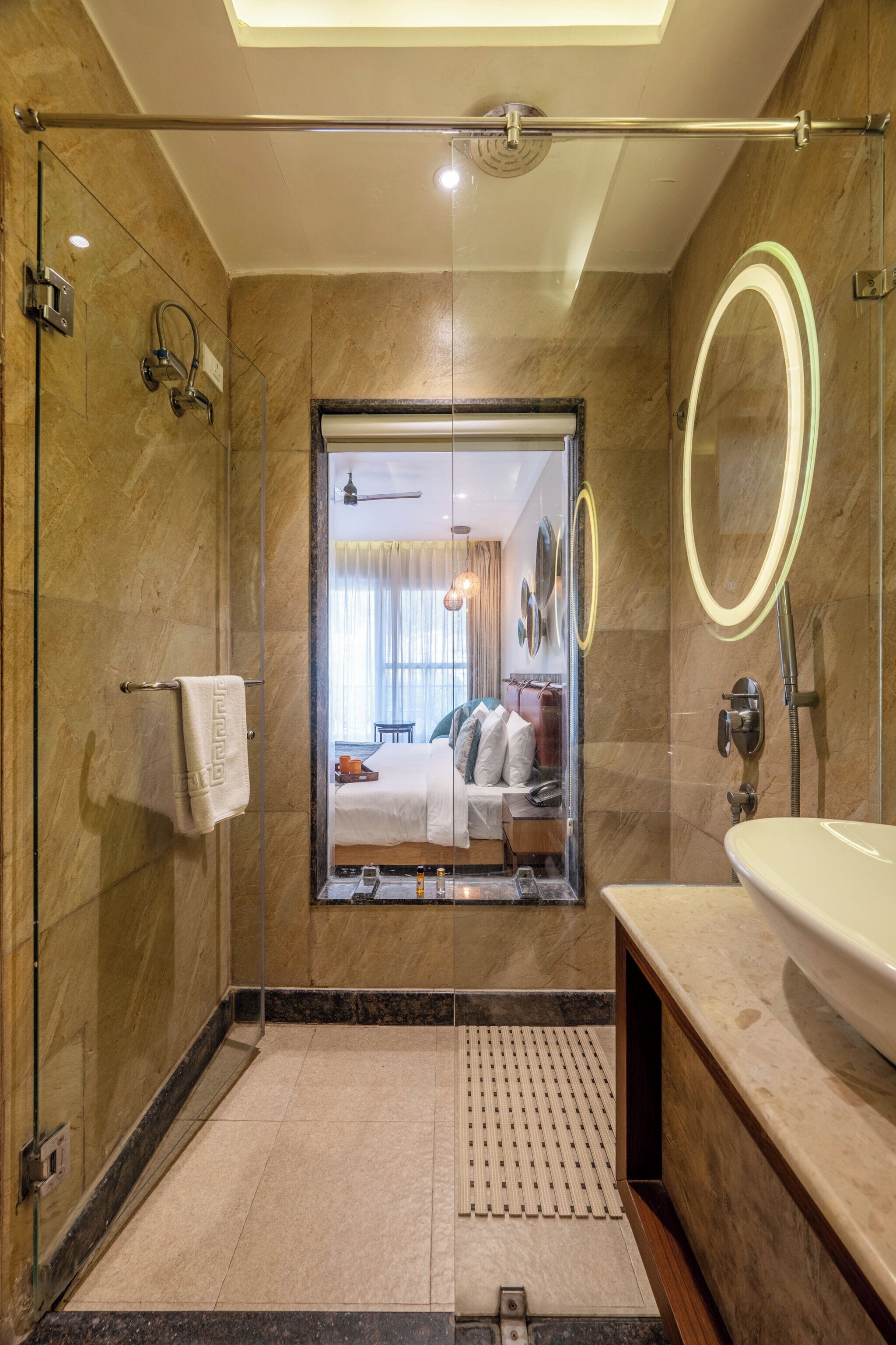 A modern bathroom with a glass-enclosed shower, a large mirror, and a sink.