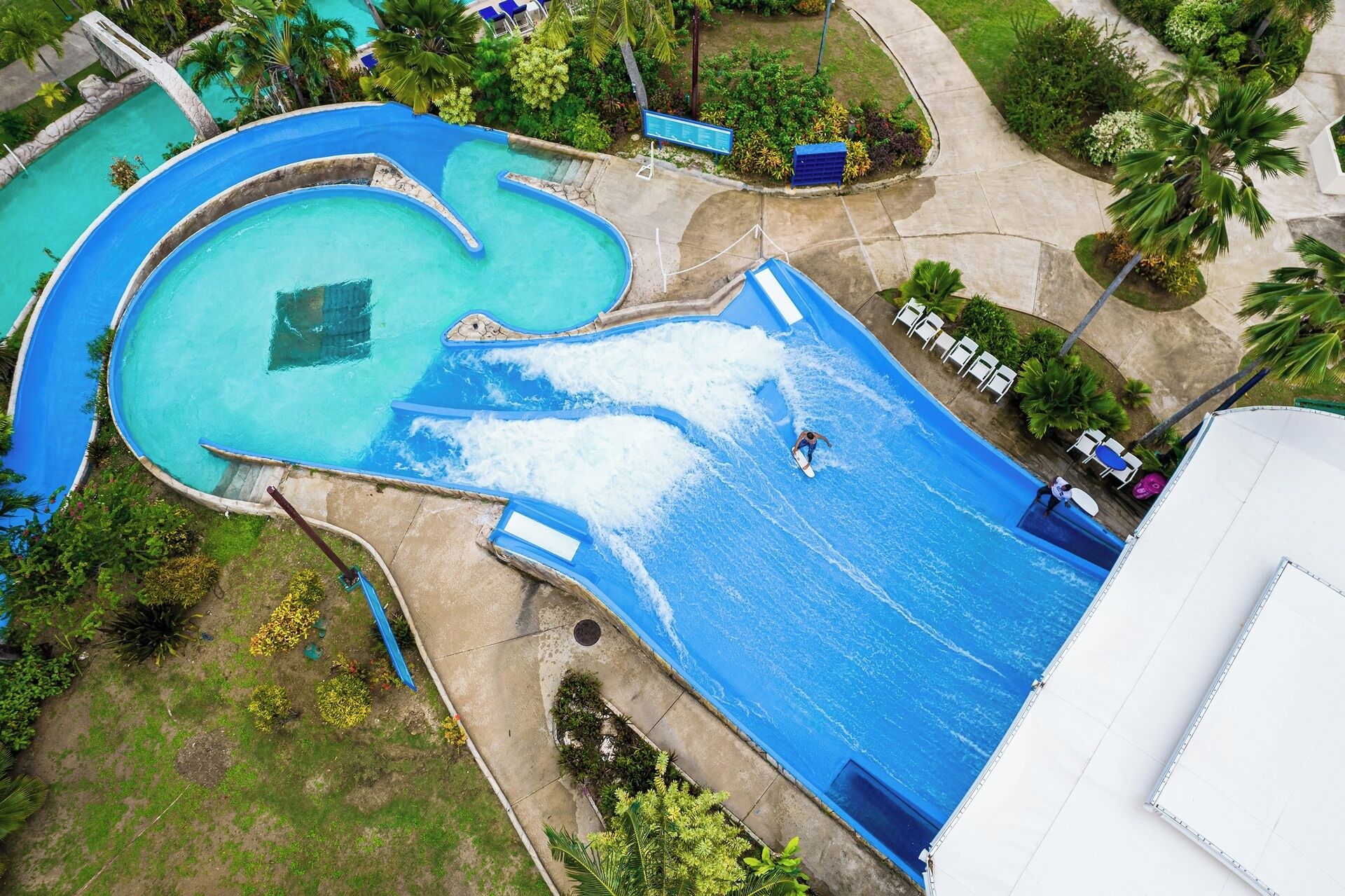 An aerial view of a water park with multiple pools and a large wave pool.