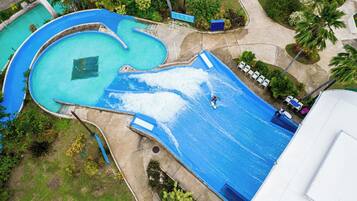 Vista aérea de un parque acuático con múltiples piscinas y una gran piscina de olas.