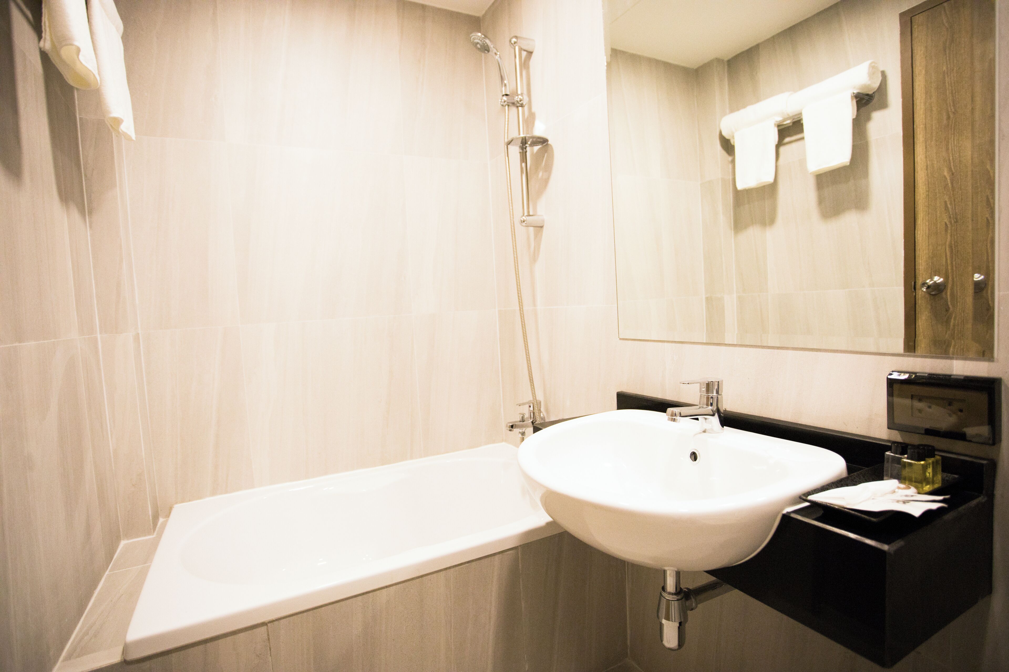Une salle de bain moderne avec une baignoire, un lavabo et un miroir.