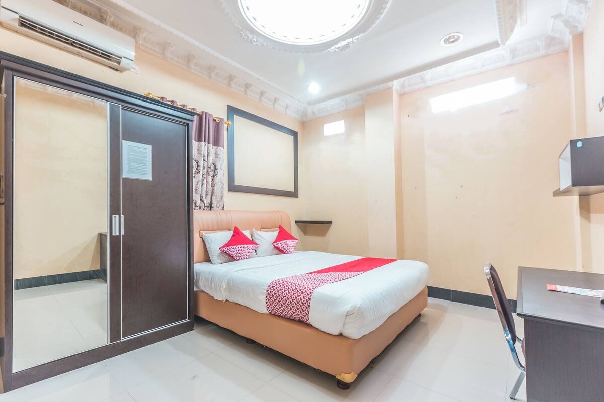 Une chambre à coucher avec un lit, un bureau et une armoire.