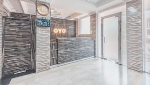 A modern reception area with a reception desk, a clock, and a wall-mounted sign that reads "OYO". - Super OYO 1640 Fallinda Hotel (Cibinong)