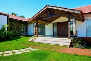 Une maison moderne dotée d’un porche abrité, d’une pelouse bien entretenue et d’un chemin en briques menant à l’entrée.