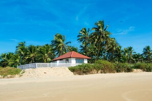 In Strandnähe, weißer Sandstrand, Sonnenschirme, Strandtücher