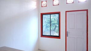 Una habitación con ventana, puerta y una mesa.