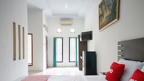 Una habitación de hotel con cama, televisor y un cuadro en la pared.