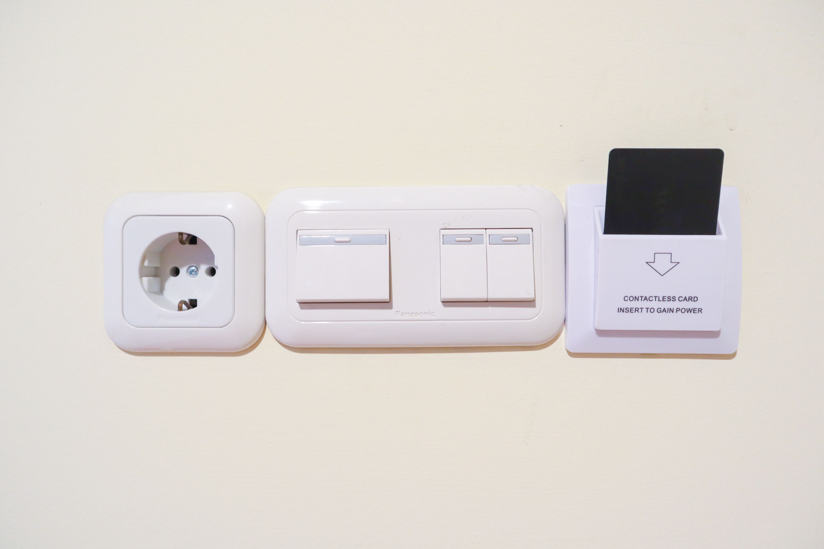 A wall-mounted electrical outlet with a contactless card reader.