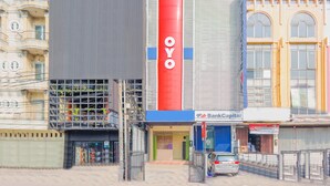 A building with a prominent red vertical sign with the letters "OYO" and a blue horizontal sign with "BankCapital". - OYO 1850 The Trend (Jakarta)