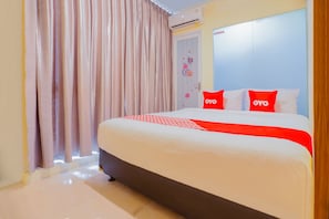 A hotel room with a large bed, a wardrobe, and a window with curtains. - OYO 1850 The Trend (Jakarta)