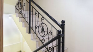 A staircase with black metal railings and a handrail. - OYO 1850 The Trend (Jakarta)