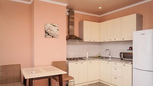 Une cuisine compacte avec un coin repas, comprenant une cuisinière, un four à micro-ondes et un réfrigérateur.