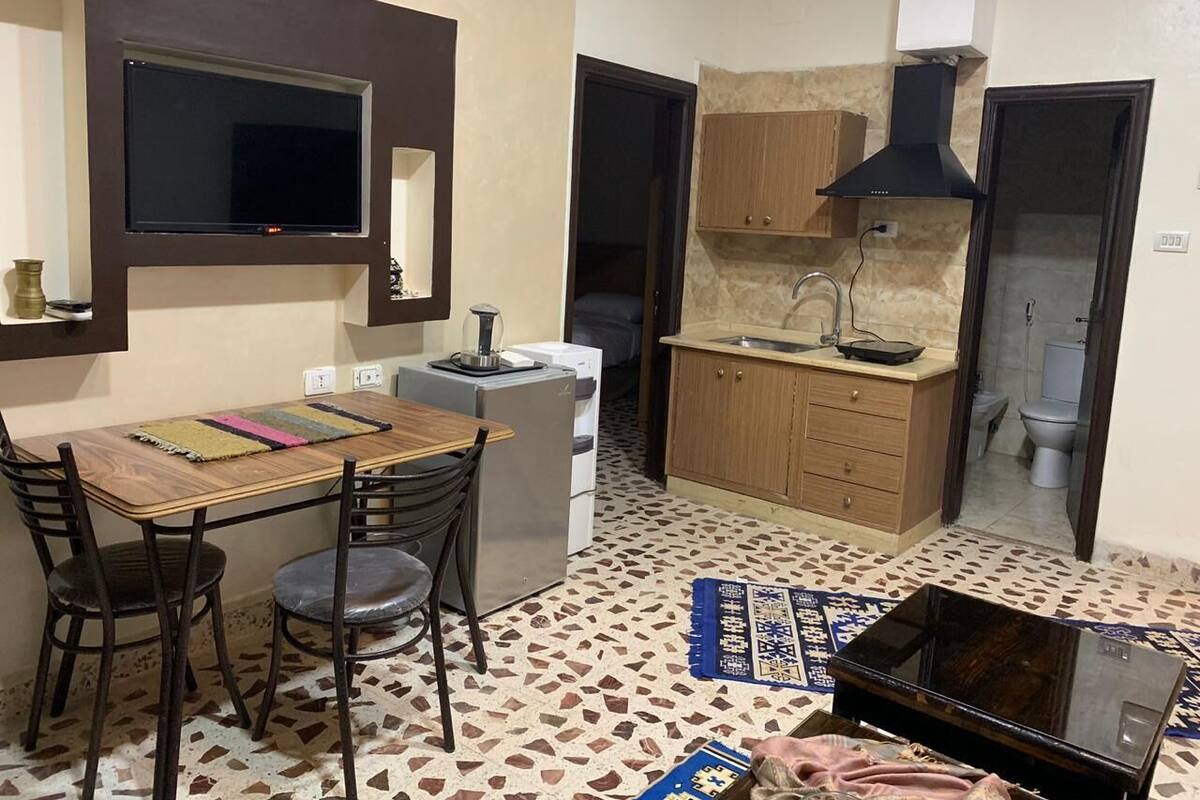 Eine kompakte Küche mit Essbereich, einem integrierten Fernseher und einem kleinen Kühlschrank.
