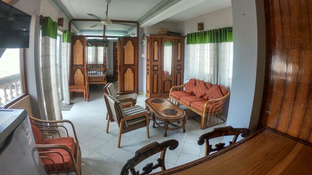 A room with a ceiling fan, wooden furniture, a sofa, and a dining table. - Private Cozy Spacious Studio in Colombo (Colombo)
