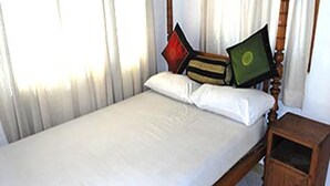 A single bed with a wooden frame, white bedding, and a nightstand with a drawer. - Private Cozy Spacious Studio in Colombo (Colombo)