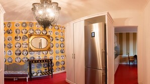 A kitchen with a stainless steel refrigerator, a bench, and a wall with circular patterns.