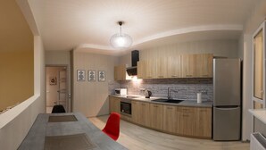 A modern kitchen with wooden cabinets, a stainless steel refrigerator, and a dining area with a table and chairs.