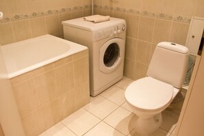 Apartment | Bathroom | Bathtub, hair dryer, slippers, towels - Apart Kiev Derevlianskaya 21A (Kyiv)