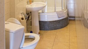 Kylpyhuone, jossa on wc, pesuallas ja suihkukaappi.