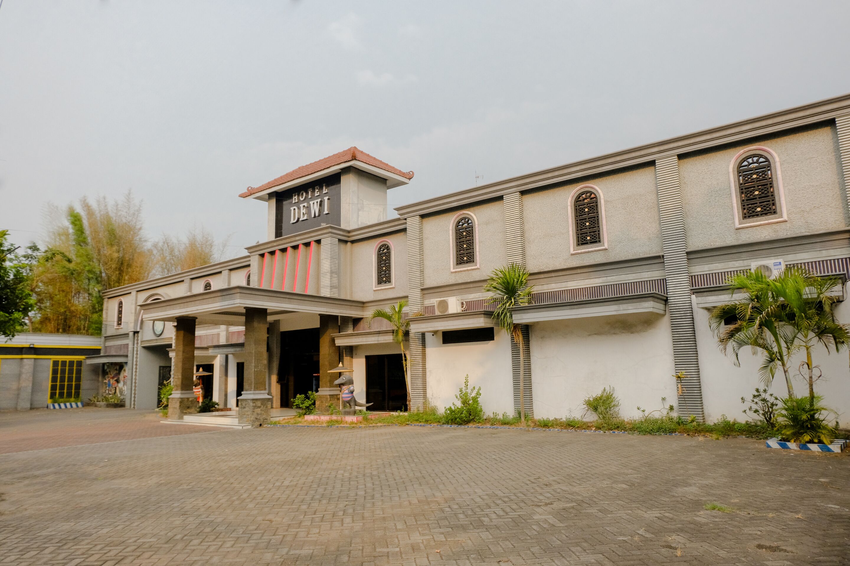 A hotel with a classic architectural style, featuring a prominent entrance with a covered area and a signboard.