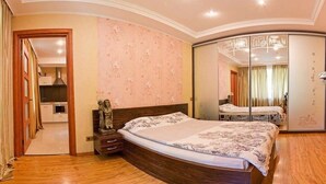 Un dormitorio con cama de madera, mesita de noche, espejo y armario.