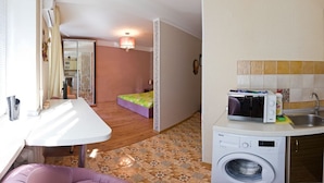 A compact kitchen with a washing machine, a microwave, and a sink. - Apart Kiev Starokievskiy pereulok 5-1 (Kyiv)