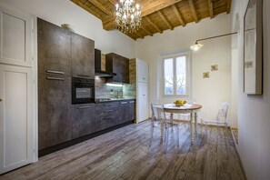 A modern kitchen with a built-in oven, a stove, and a large window.