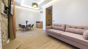 Una sala moderna con sofá, mesa de comedor, sillas y una zona de cocina.