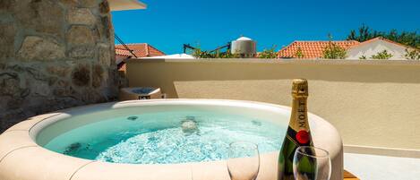 Un jacuzzi con una botella de Moët & Chandon y dos copas sobre una mesa de madera.