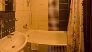 A bathroom with a bathtub, a sink, and a shower curtain. - Apart Kiev Starokievskiy pereulok 5-2 (Kyiv)
