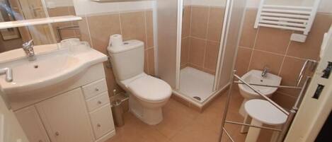 A bathroom with a toilet, sink, and shower.
