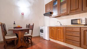 A kitchen with wooden cabinets, a white stove, and a microwave.