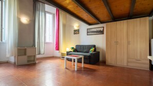 A living room with a wooden ceiling, a sofa, a small table, and a cabinet.