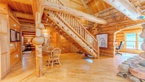 Interior de madera con una escalera espiral, paredes de madera y un revestimiento de pared de piedra.